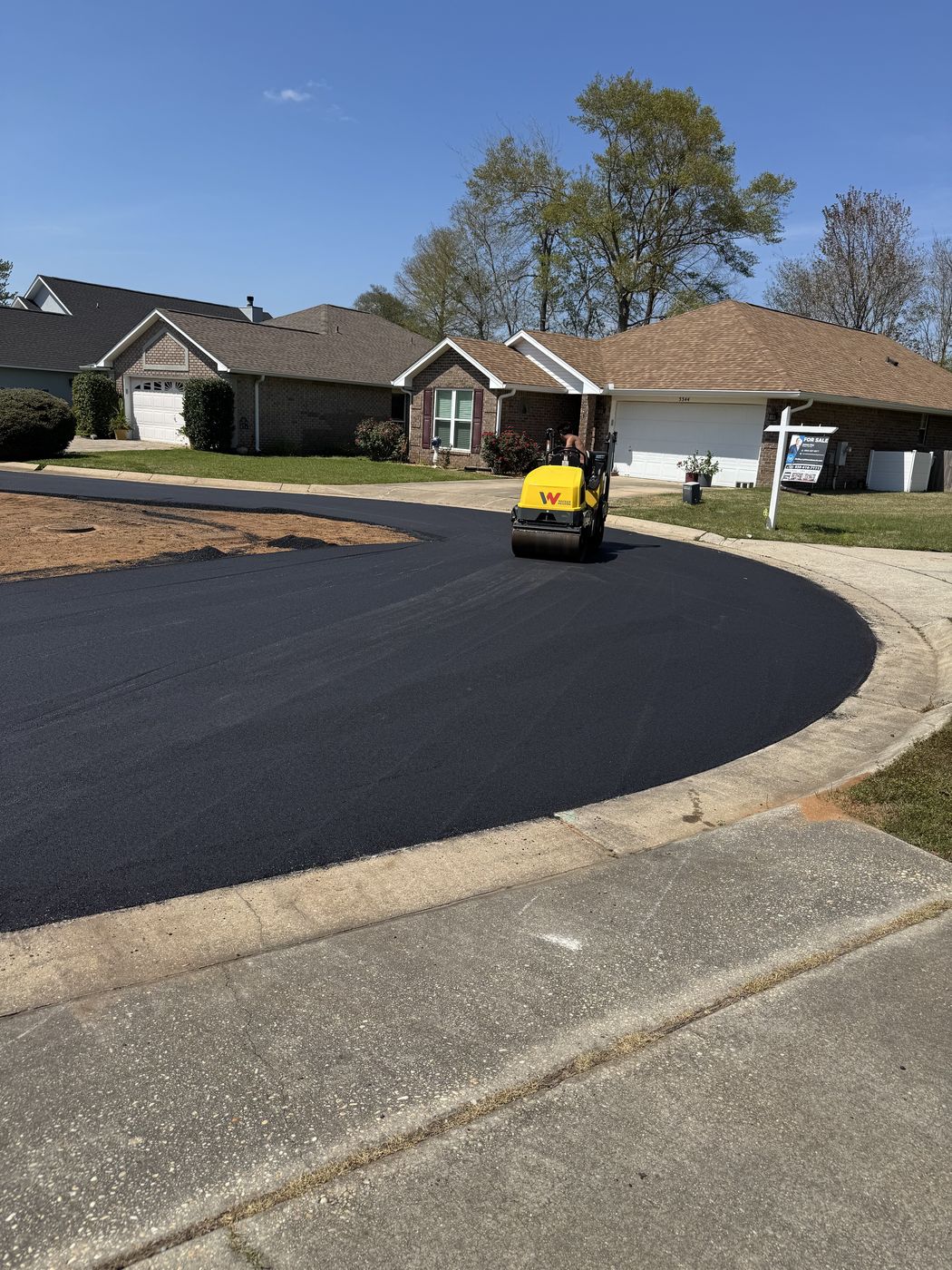 Roller compacting a freshly paved residential street