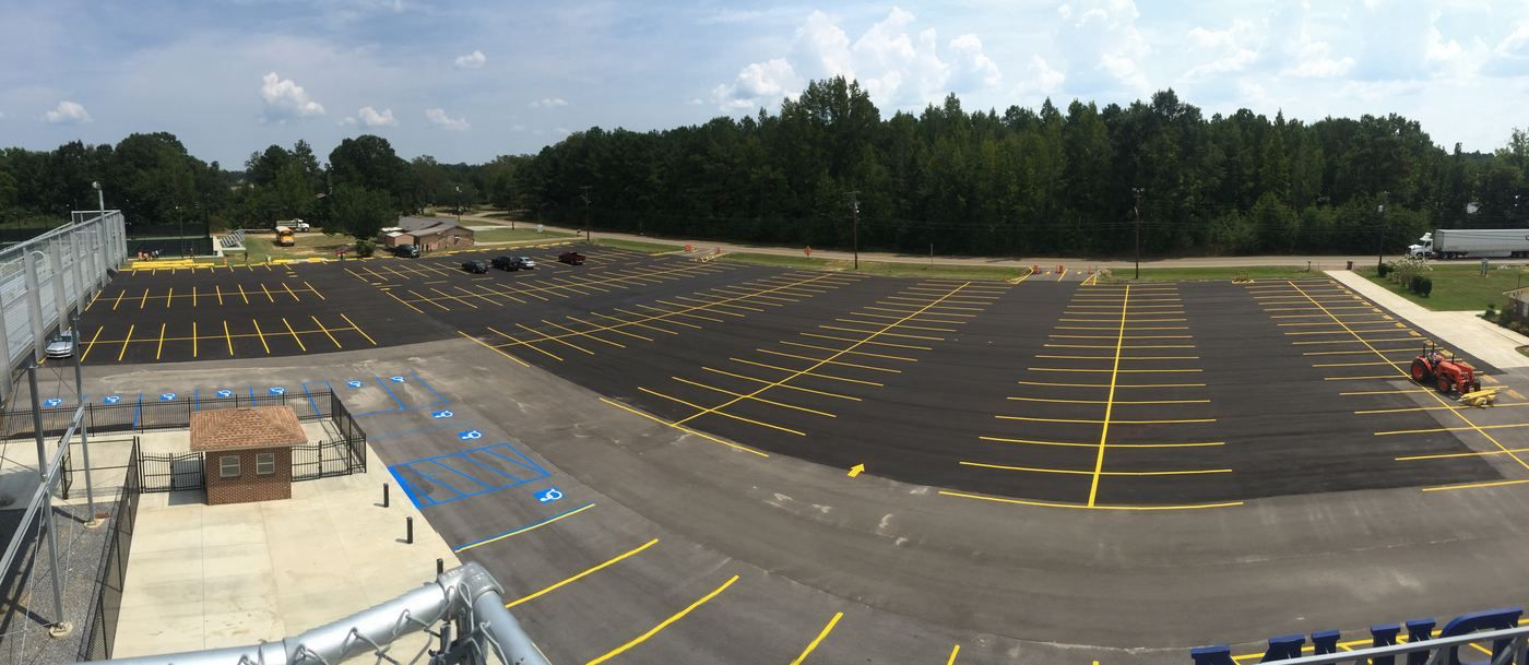 Freshly striped school parking lot with yellow stalls and blue ADA area